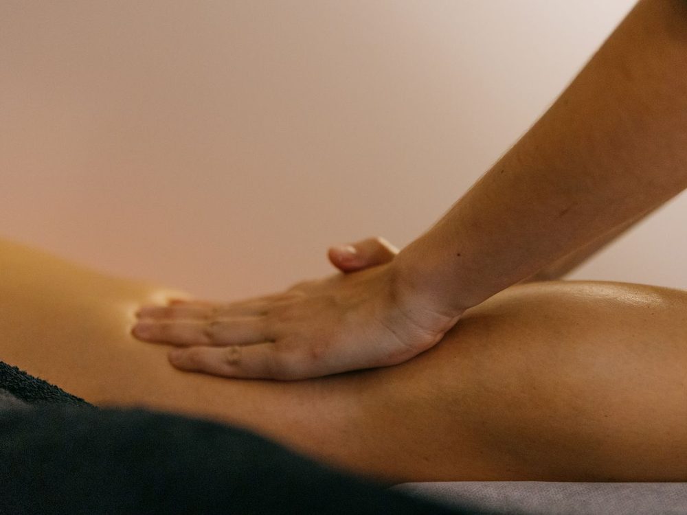 Sanfte Ausstreichung des Beines mit flachen Händen – Grifftechnik der manuellen Lymphdrainage