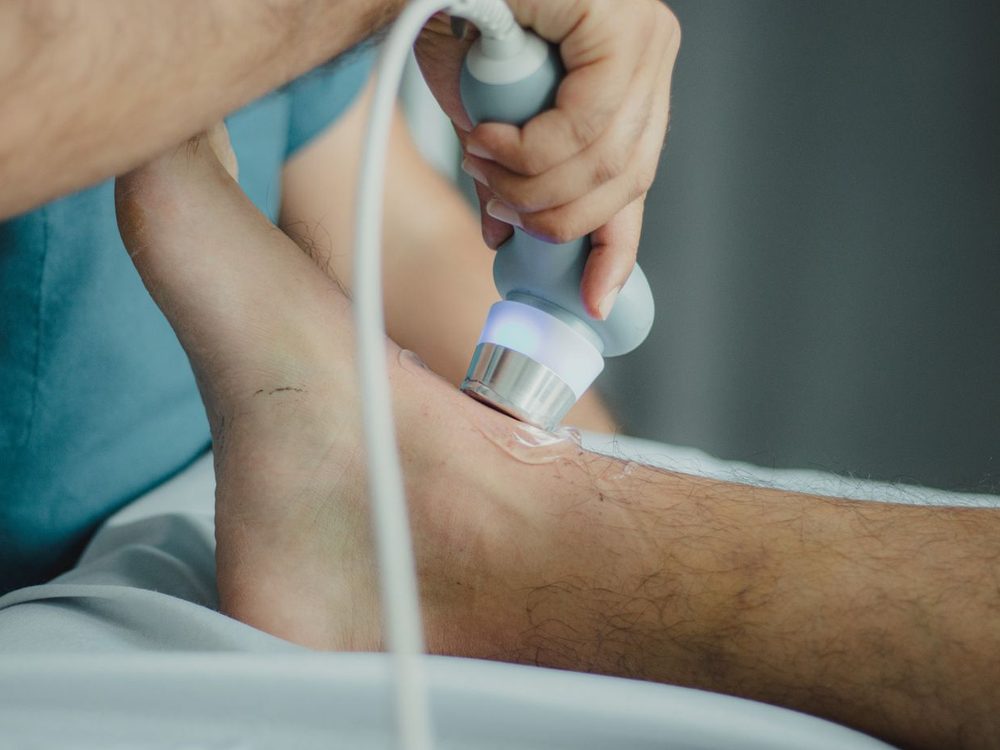 Behandlung des Unterschenkels mit einem Ultraschallkopf in der physikalischen Therapie